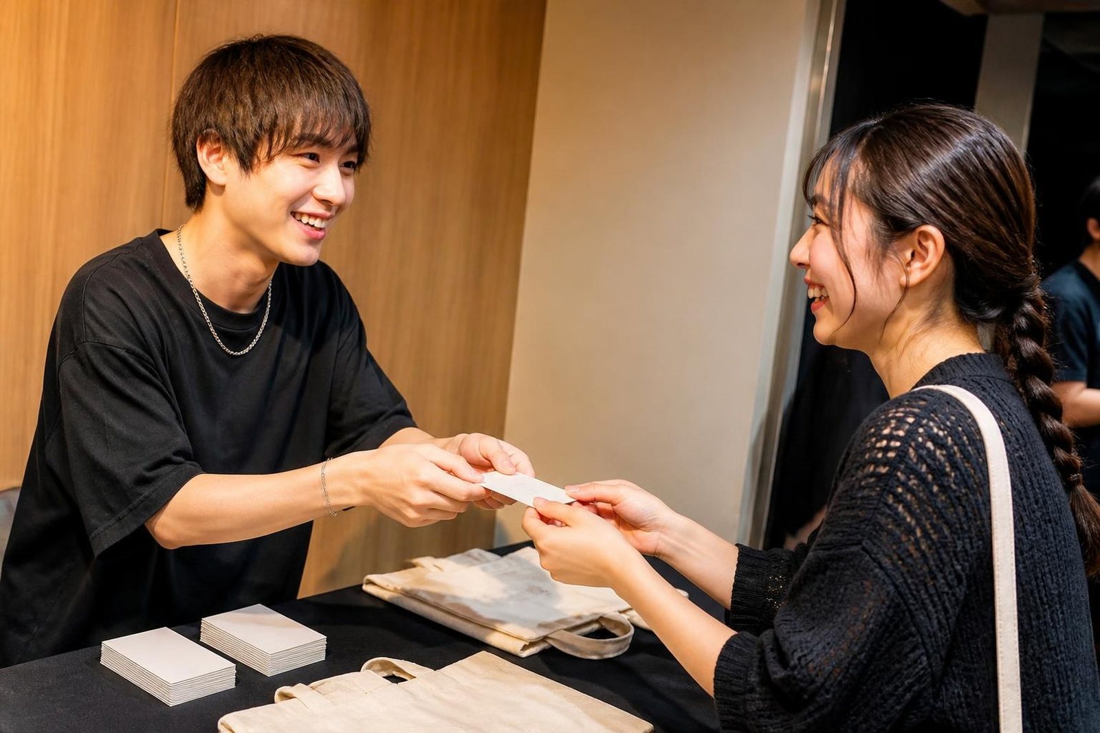 ライブのあと物販の机でファンにカードを渡すアーティスト
